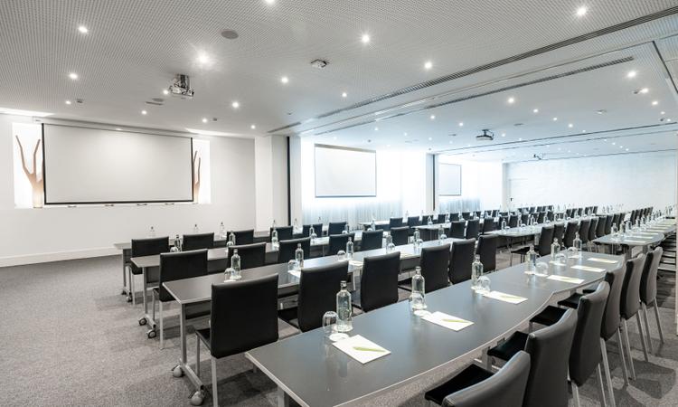 Rosaleda A Nuevo Boston Hotel Madrid- Airport The Rosaleda space consists of three rooms A+B+C, totaling 270 square meters and featuring natural light. It can be divided into three functional rooms, accommodating up to 225 people in a theater-style layout. Additionally, our spaces are equipped with the necessary technology to carry out your meetings and events efficiently Nuevo Boston Hotel Madrid- Airport